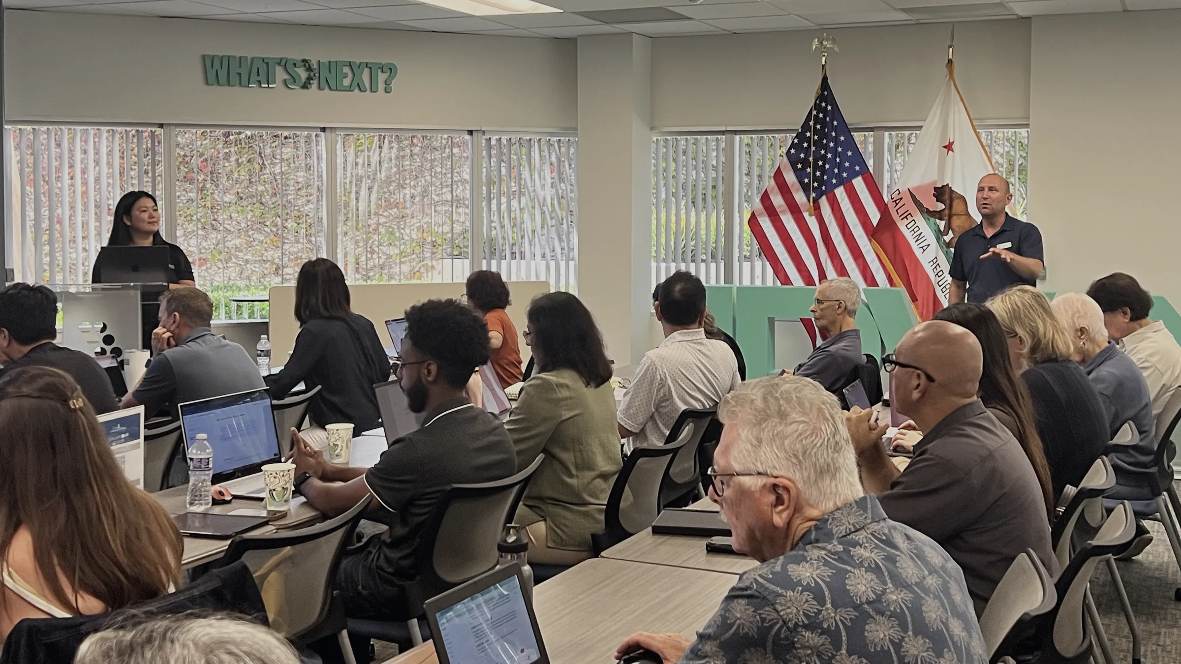 Small business owners on laptops listening to presenters at a free CIF AI workshop