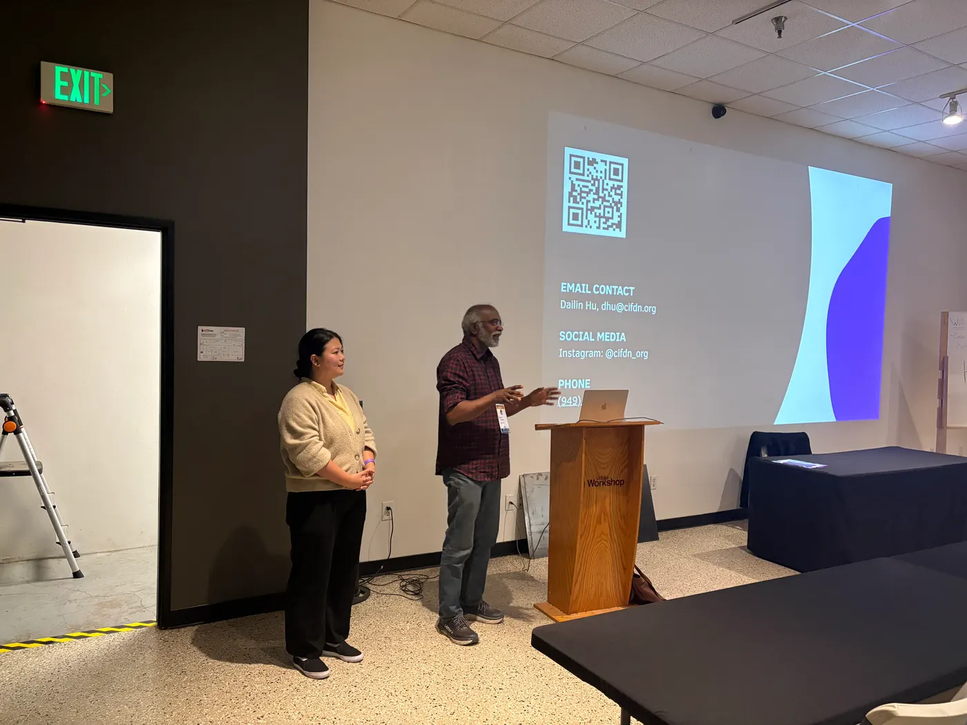 Two presenters standing beside a projected slide at the front of the workshop room at Urban Workshop in Costa Mesa.